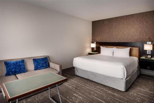 a hotel room with a bed and a couch at Hyatt Regency Indianapolis at State Capitol in Indianapolis
