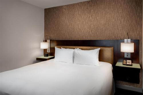 a large bed in a hotel room with two lamps at Hyatt Regency Indianapolis at State Capitol in Indianapolis