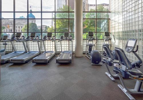 a gym with rows of tread machines in a building at Hyatt Regency Indianapolis at State Capitol in Indianapolis