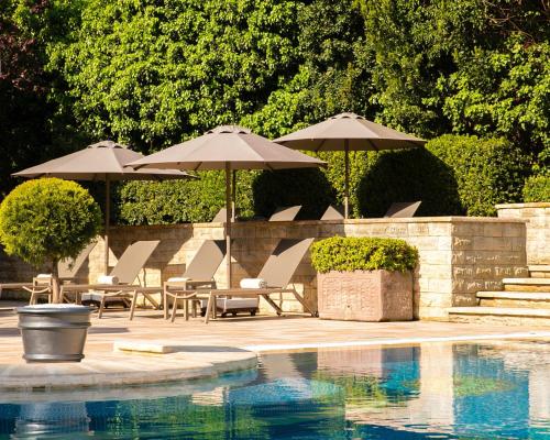 a swimming pool with umbrellas and chairs and a swimming pool at Grand Hyatt Istanbul in Istanbul