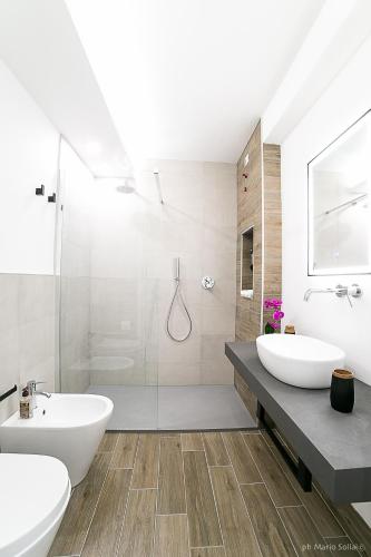 a white bathroom with two sinks and a shower at Casa Sollai in Monserrato