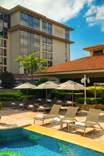 a hotel with chairs and umbrellas next to a pool at Grand Hyatt Istanbul in Istanbul