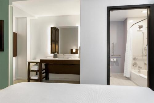 une salle de bain avec un lavabo et un miroir dans l'établissement Hyatt Place West Palm Beach, à West Palm Beach