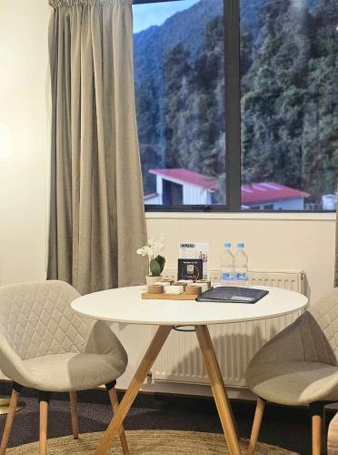 a table and two chairs in front of a window at Wild Kea Lodge Franz Josef in Franz Josef