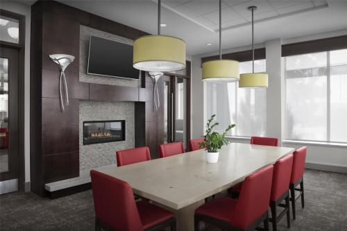 a dining room with a table and chairs and a fireplace at Hilton Garden Inn Gallup in Gallup