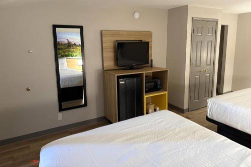 a hotel room with two beds and a flat screen tv at Days Inn by Wyndham Reno in Reno