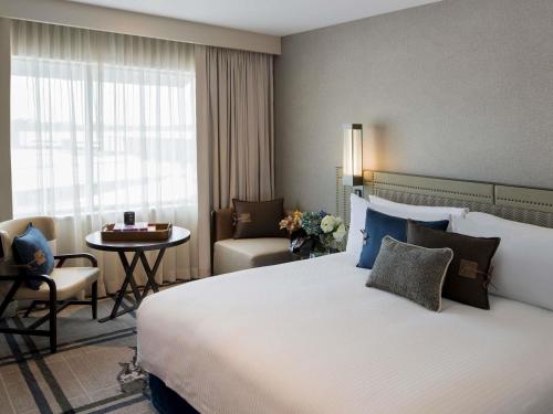 a hotel room with a large bed and a table at The William Inglis Mgallery in Warwick Farm