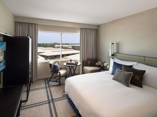 a hotel room with a large bed and a balcony at The William Inglis Mgallery in Warwick Farm