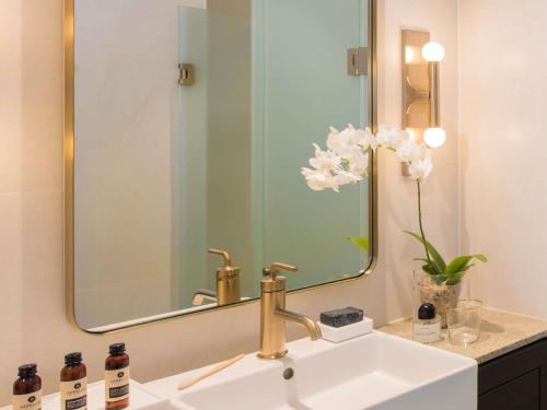 a bathroom sink with a large mirror above it at The William Inglis Mgallery in Warwick Farm