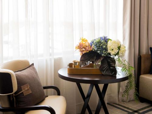 a table with a vase of flowers on top of it at The William Inglis Mgallery in Warwick Farm