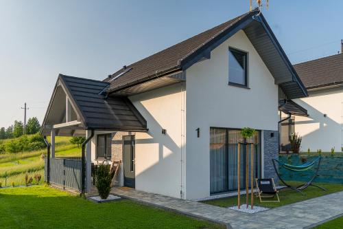 a white house with a black roof at DOMINO-domek 3 in Krościenko