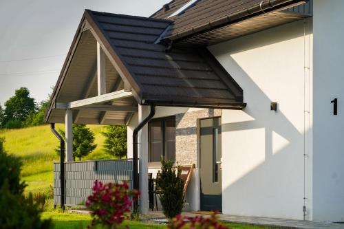 a house with a metal roof on top of it at DOMINO-domek 3 in Krościenko