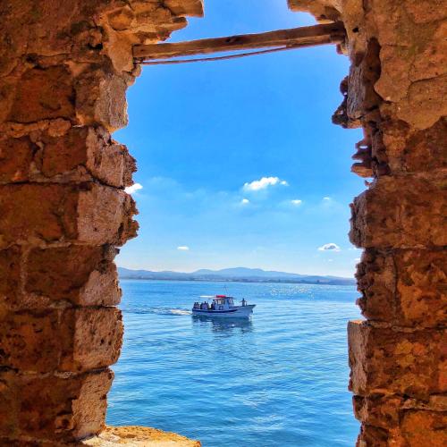 a boat on the water seen through a window at Maiolica in Trapani