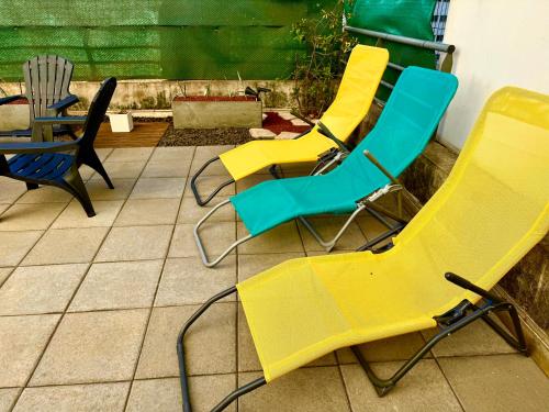 a group of yellow and blue chairs on a patio at T3 Le Frangipanier - Terrasse Jardin & Jacuzzi in Saint-Denis