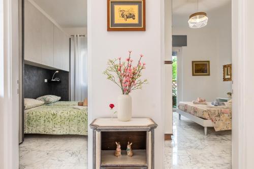 un soggiorno con letto e un vaso sul tavolo di Casa Lauretta a Viareggio
