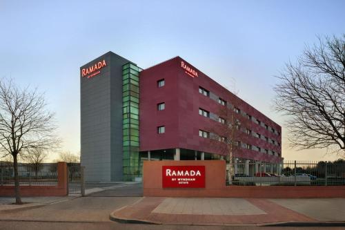 a tall red building with a sign on it at Ramada by Wyndham Madrid Getafe in Getafe