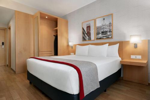 a bedroom with a large white bed in a room at Ramada by Wyndham Madrid Getafe in Getafe