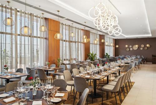 a row of tables and chairs in a room with windows at Doubletree By Hilton Addis Ababa Airport in Addis Ababa
