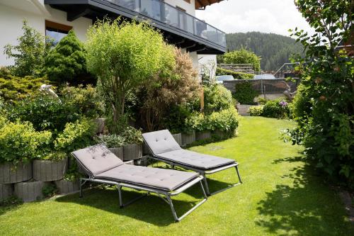 two chairs sitting on the grass in a garden at Apart Sunnbichl in Nauders