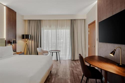 a hotel room with a bed and a desk and a table at Doubletree By Hilton Addis Ababa Airport in Addis Ababa