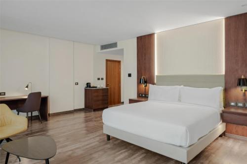 a bedroom with a large white bed and a desk at Doubletree By Hilton Addis Ababa Airport in Addis Ababa