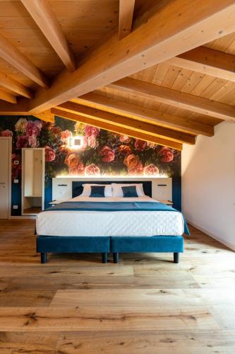a bedroom with a bed with a floral wall at 4 Elementi Relais B&B Lonato del Garda in Lonato del Garda
