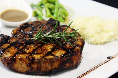 a white plate with a piece of meat with a side of broccoli at Hotel Club Akumal Caribe in Akumal