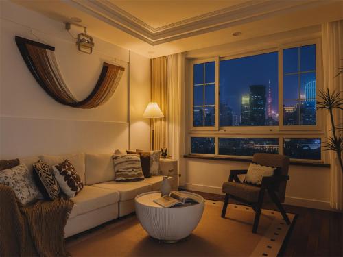 a living room with a couch and a window at Book and Bed-People's Square in Shanghai