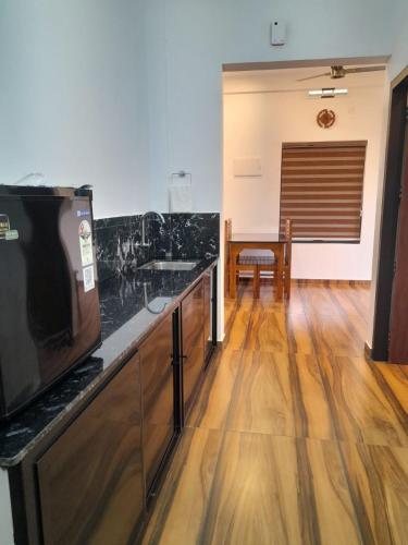 a kitchen with black marble counter tops and a table at VGK Residency in Wayanad