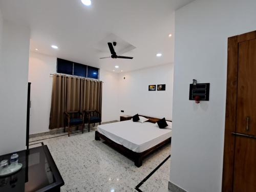 a bedroom with a bed and a ceiling fan at Uttam Hotel & Restaurant in Guwahati