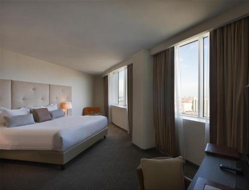 a hotel room with a bed and a large window at Grand Mogador City Center in Casablanca