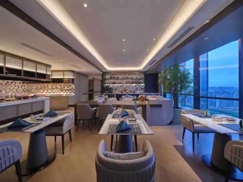 a restaurant with tables and chairs and a bar at Hilton Jiashan in Jiaxing