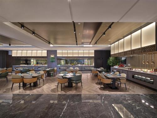 a restaurant with tables and chairs and a bar at Hilton Jiashan in Jiaxing