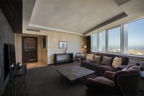a living room with a couch and a television at Grand Mogador City Center in Casablanca