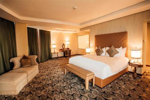 a hotel room with a large bed and a couch at Grand Mogador City Center in Casablanca