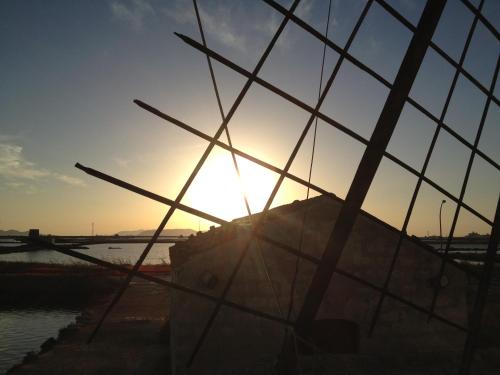 a view of the sunset through a fence at Maiolica in Trapani