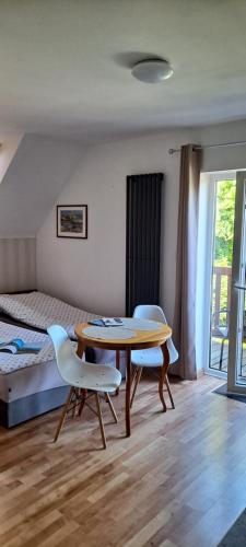 a room with a table and two chairs and a bed at Pokoje gościnne Keja in Wisełka