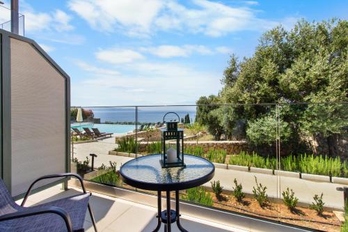 a table on a balcony with a view of the ocean at Momento Suites in Vlachata