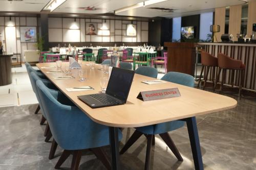 a laptop sitting on a table in a restaurant at Ramada Encore by Wyndham Chandigarh Zirakpur in Zirakpur