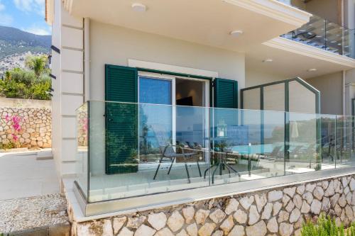 a house with a balcony with green shutters at Momento Suites in Vlachata
