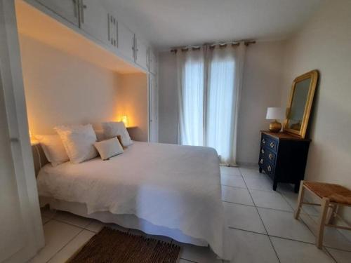 une chambre avec un grand lit blanc et un miroir dans l'établissement Beach front apartment in Hossegor, à Hossegor
