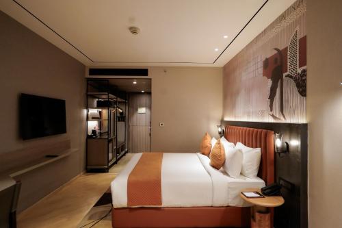 a hotel room with a bed and a television at Ramada Encore by Wyndham Chandigarh Zirakpur in Zirakpur