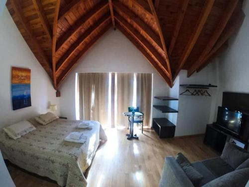 a bedroom with a large bed and a couch at Hostería kaime in Caviahue
