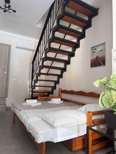 a bedroom with a bed and a staircase at Mariam Apartment in Nea Moudania