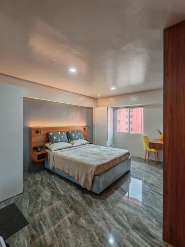 a bedroom with a large bed and a table at Traveler's Nest near Airport, Netflix, Stylish, Cozy with swimming pool in Lapu Lapu City