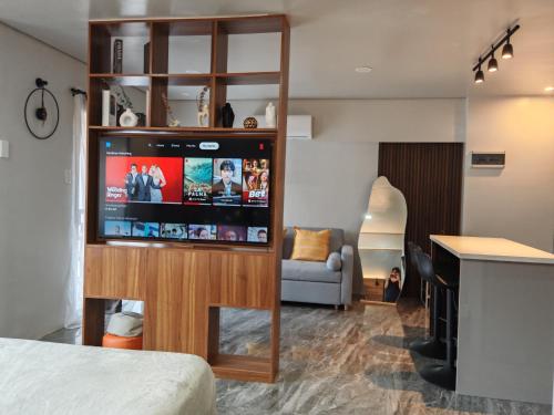 a living room with a television and a couch at Traveler's Nest near Airport, Netflix, Stylish, Cozy with swimming pool in Lapu Lapu City