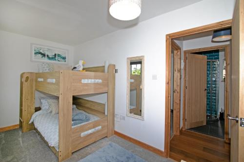 a bunk bed in a room with a mirror at 7 Porth Valley Cottage's in Newquay