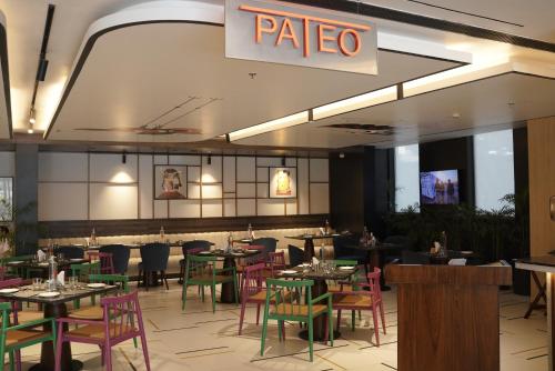 a restaurant with tables and chairs and a sign on the wall at Ramada Encore by Wyndham Chandigarh Zirakpur in Zirakpur