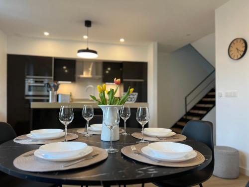 a dining room table with plates and wine glasses at Le Cocon des Tilleuls - Duplex 2 Ch - Parking inclus au pied du logement ! in Liège
