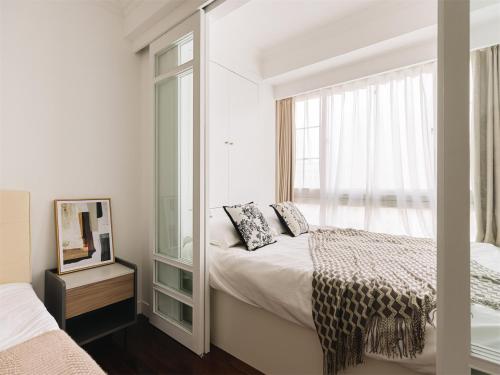 a white room with a bed and a mirror at Book and Bed-People's Square in Shanghai